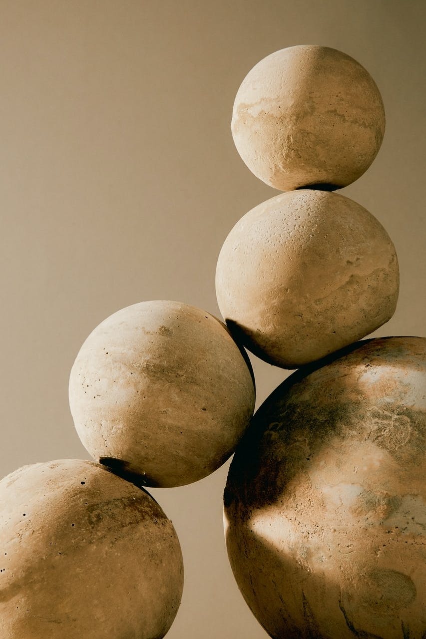five rocks stacked on top of each other with tan background